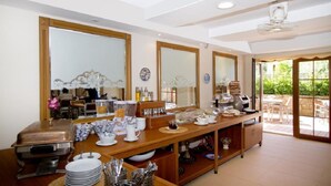 A breakfast buffet setup with a coffee machine, tea station, and various food containers. - Summer Otel (Ula)