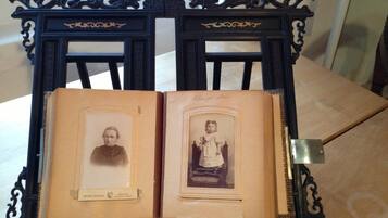 An open book with two framed photographs on a wooden table.