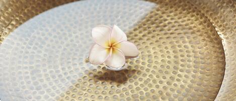 A close-up of a textured bowl with a single flower.