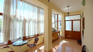 A spacious room with a dining area, a kitchen, and a view of the outside.