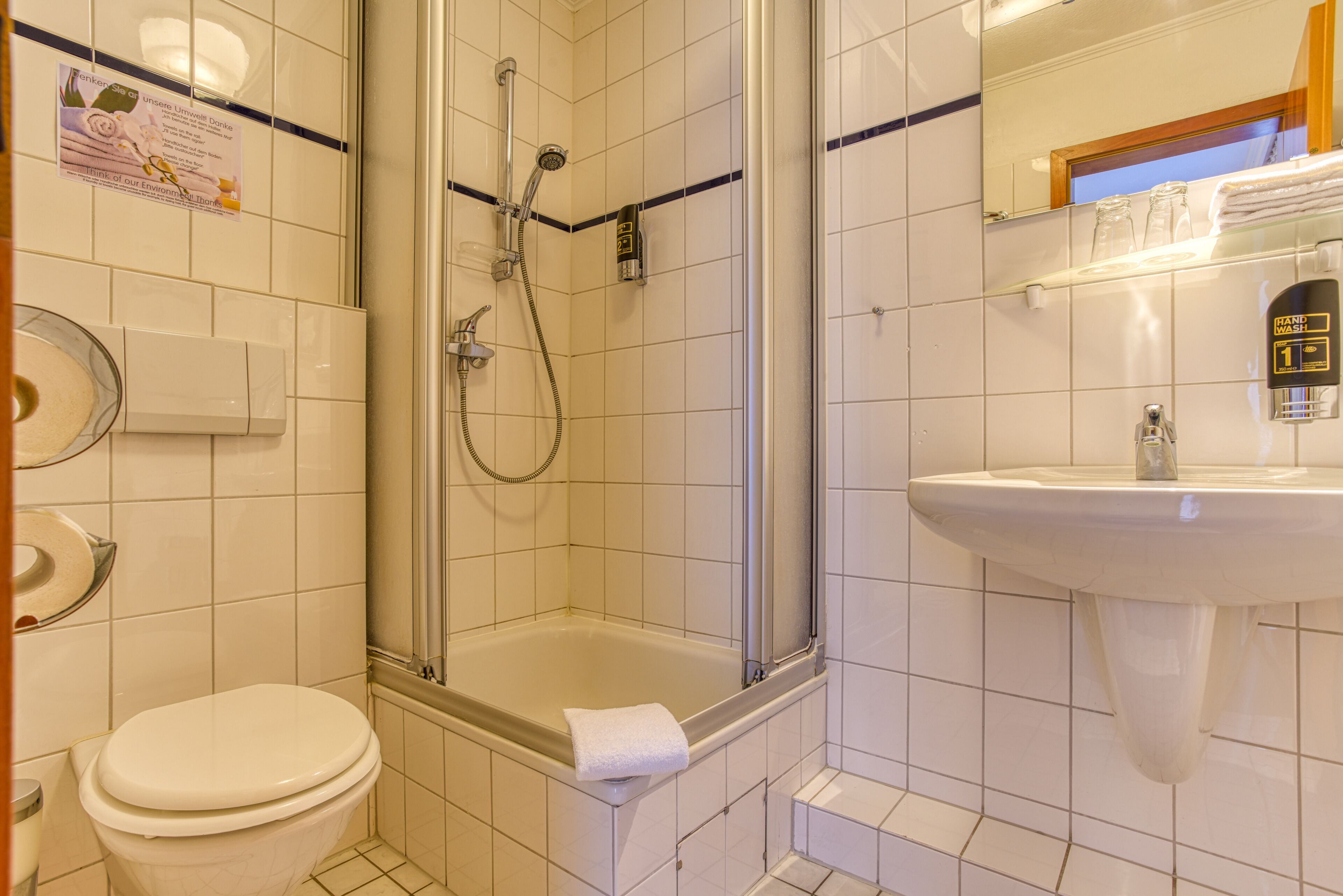 Un baño con inodoro, ducha y lavamanos.