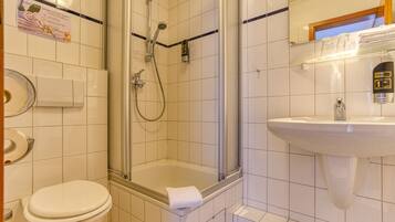 Un baño con inodoro, ducha y lavamanos.