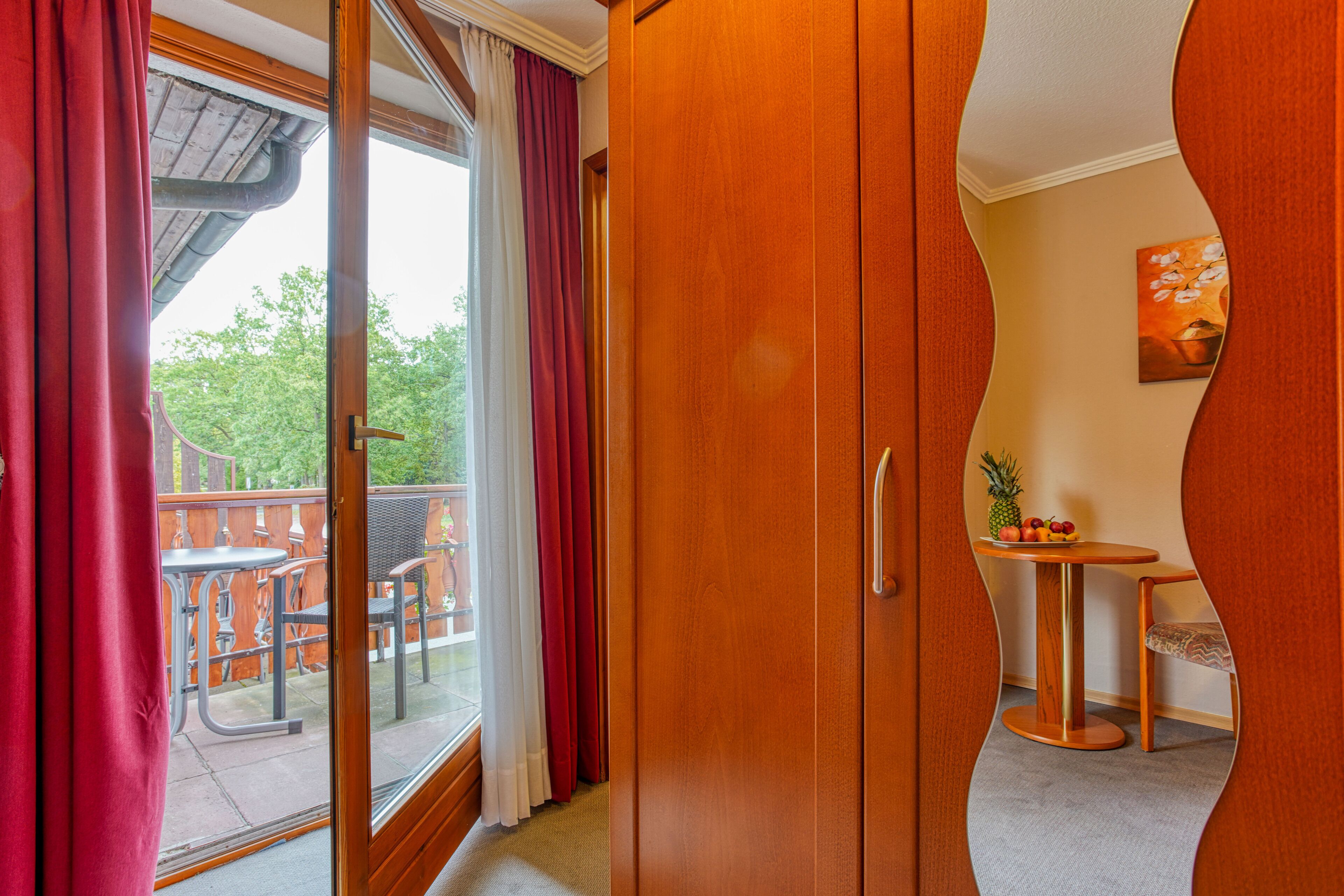 A room with a sliding glass door leading to an outdoor patio with a table and chairs.
