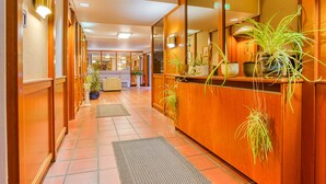 A hotel lobby with wooden paneling, a reception desk, and potted plants. - Sport Hotel Bad Bevensen (Bad Bevensen)