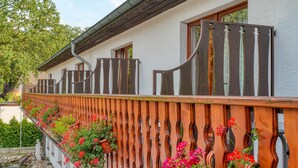 A building with a white exterior, a wooden fence, and a small pond with a statue. - Sport Hotel Bad Bevensen (Bad Bevensen)