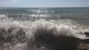 A beach with waves crashing onto the shore.