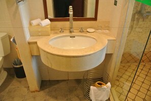 A bathroom with a sink, mirror, and toiletries.
