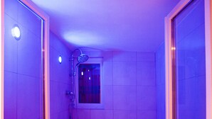 A small, modern bathroom with a shower, a window, and a bench. - Manoir François 1er (Vitry-le-Francois)
