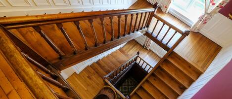 A wooden staircase with a handrail leading to a landing.