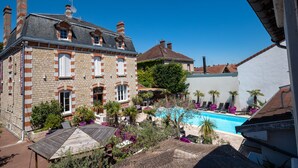 A large stone building with a swimming pool, surrounded by lush greenery and palm trees. - Manoir François 1er (Vitry-le-Francois)