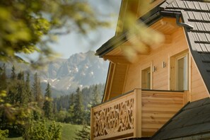 A wooden cabin with a balcony overlooking a mountainous landscape. - Villa 11 Folk & Design (Zakopane)