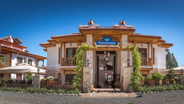 A building with a sign reading "Panamare" and a balcony with a view.
