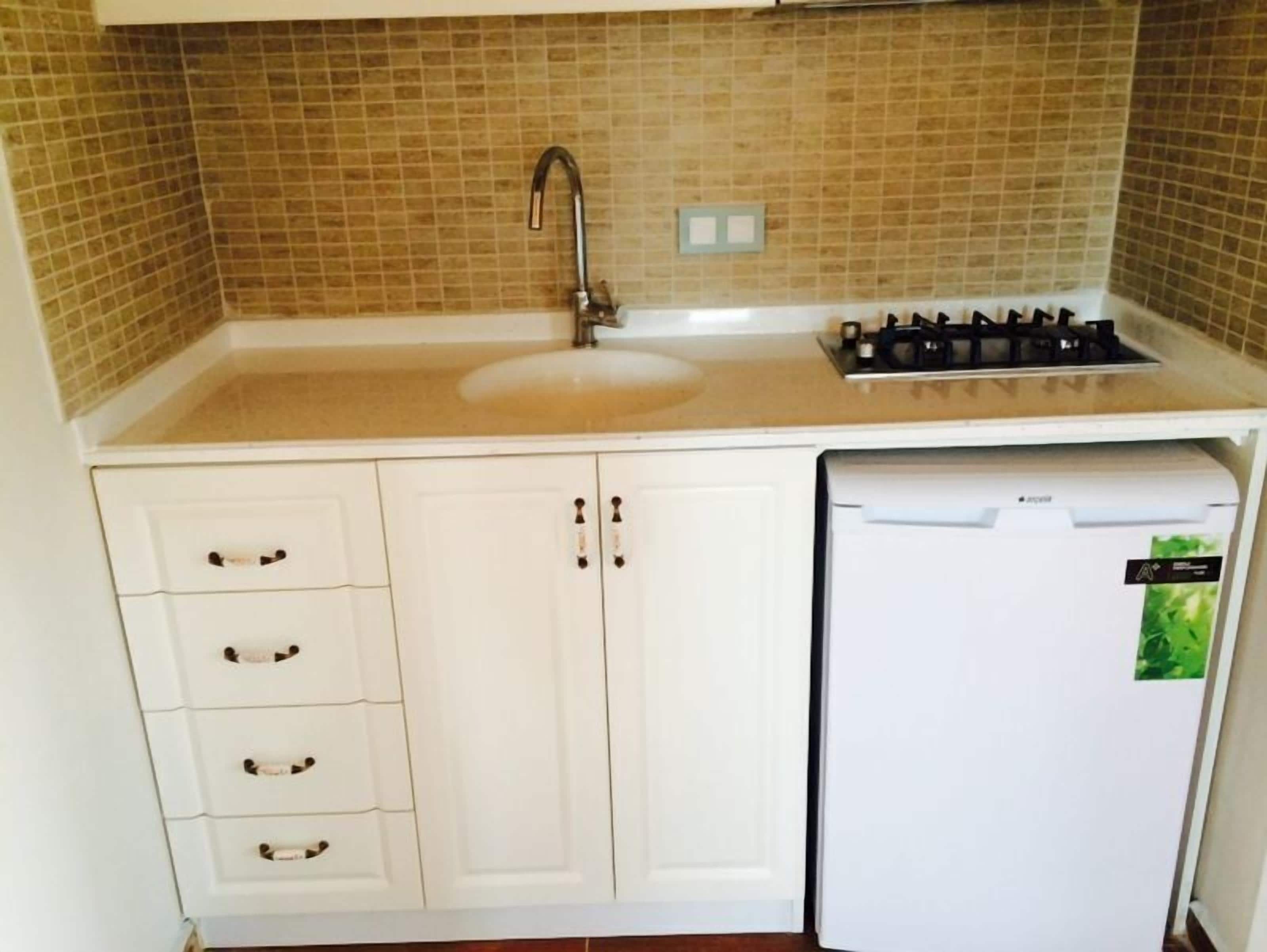 A kitchen with a sink, stove, and dishwasher.