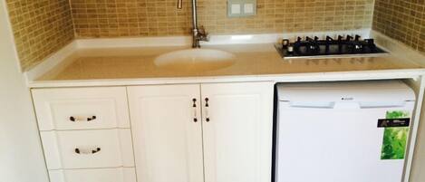 A kitchen with a sink, stove, and dishwasher.
