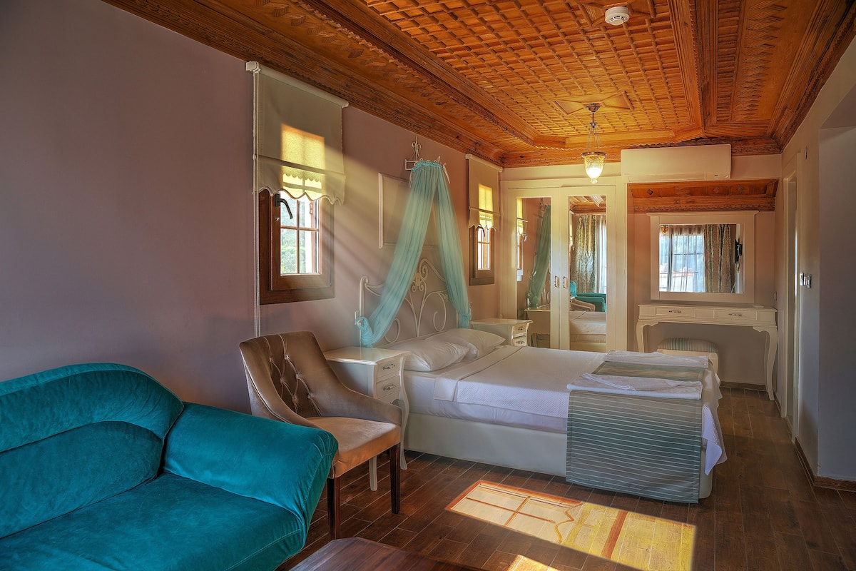 Une chambre à coucher avec un lit, une chaise, un canapé et un bureau.