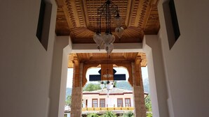 An interior view with a wooden ceiling and a view of a building outside.
