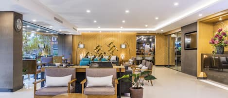 A modern hotel lobby with wooden paneling, comfortable seating, and a reception desk.