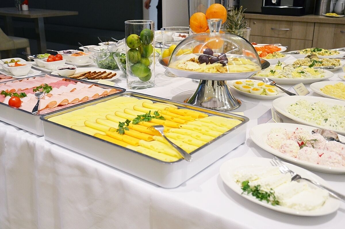 Un buffet con diverse opzioni tra cui pasta, insalate e frutta.