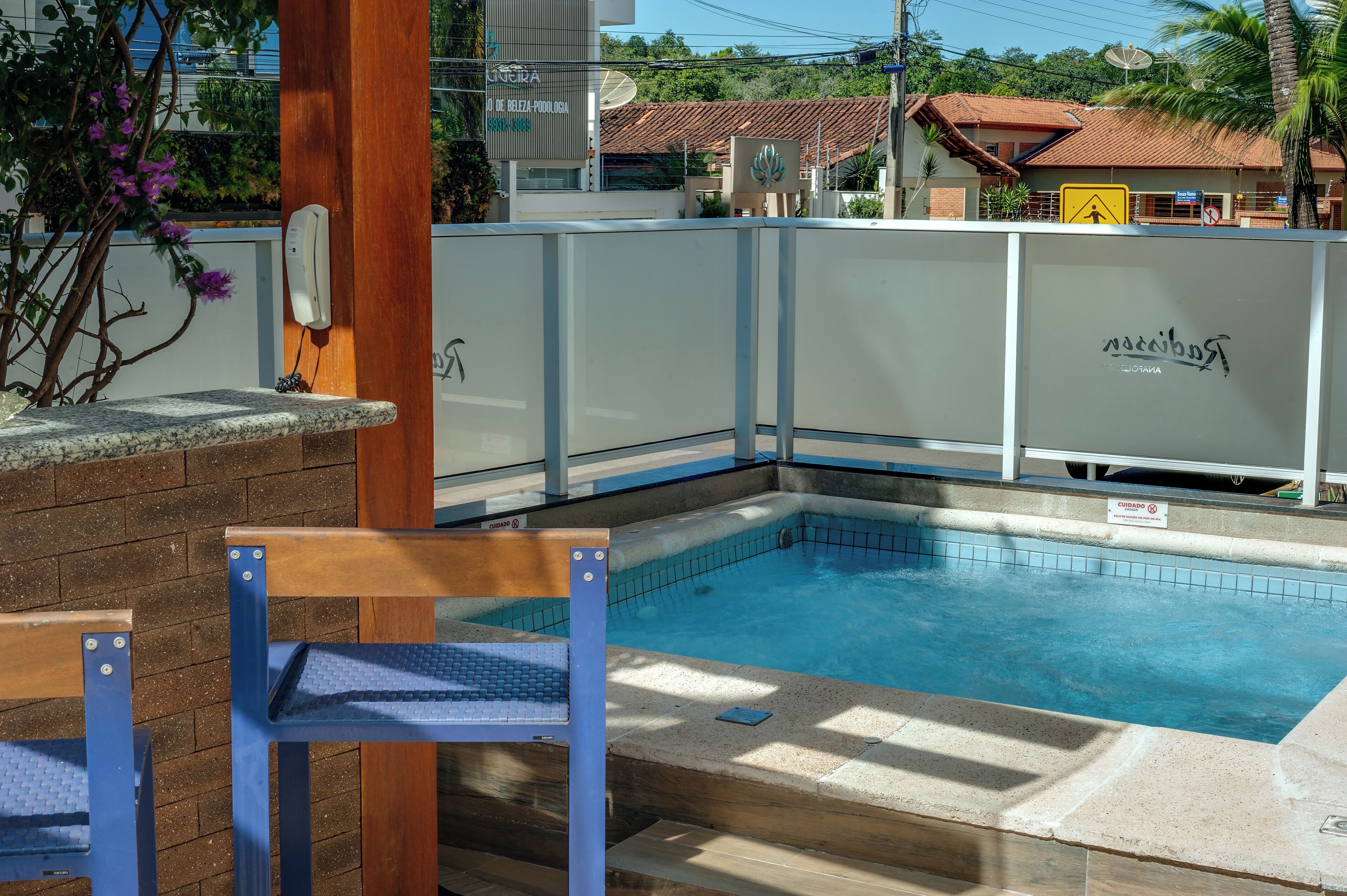 Une piscine avec un banc en bois et une clôture blanche.