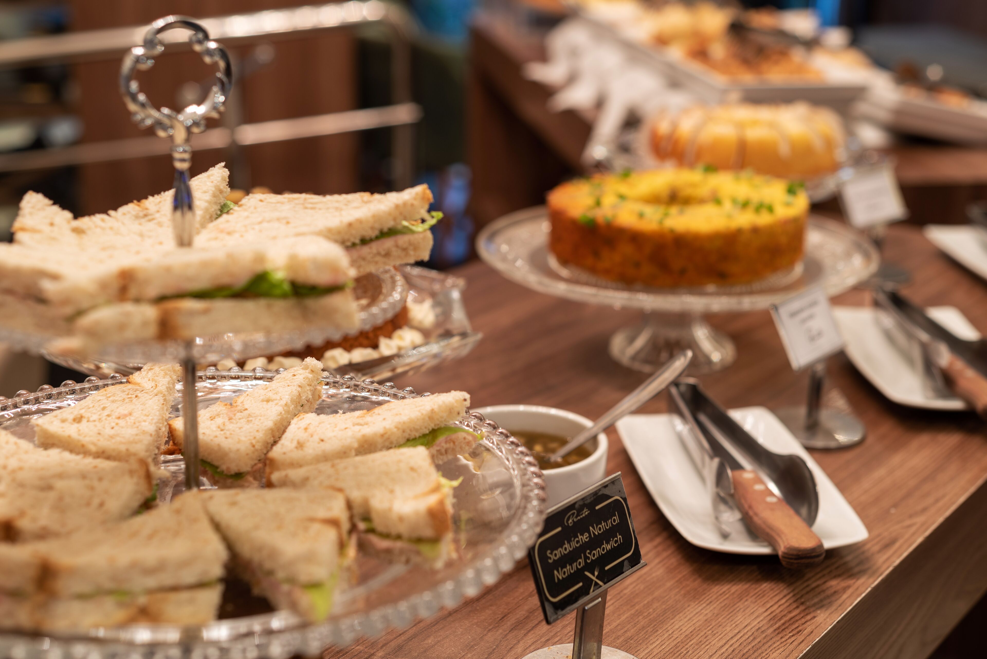 En buffet med forskellige sandwiches og en kage.