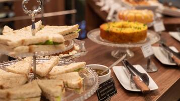 En buffet med forskellige sandwiches og en kage.
