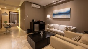 A modern living room with a sofa, a coffee table, and a dining area with a table and chairs. - Radisson Hotel Anapolis (Anapolis)