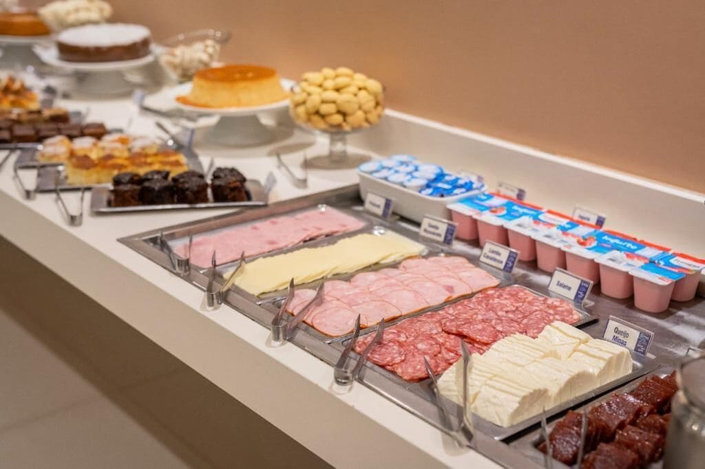 A buffet with various food options including meats, cheeses, and desserts.
