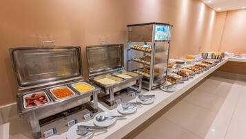 A buffet setup with various food items and utensils.