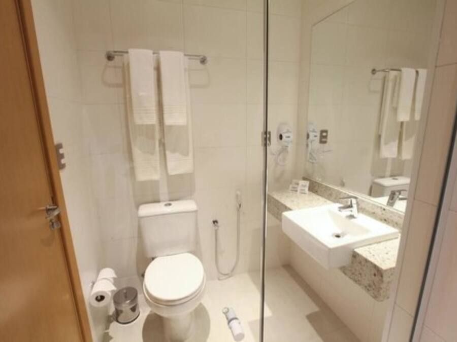 A modern bathroom with a toilet, shower, and sink.