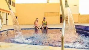 A couple sitting by a pool with water jets. - Hotel do Grande Rio (Petrolina)