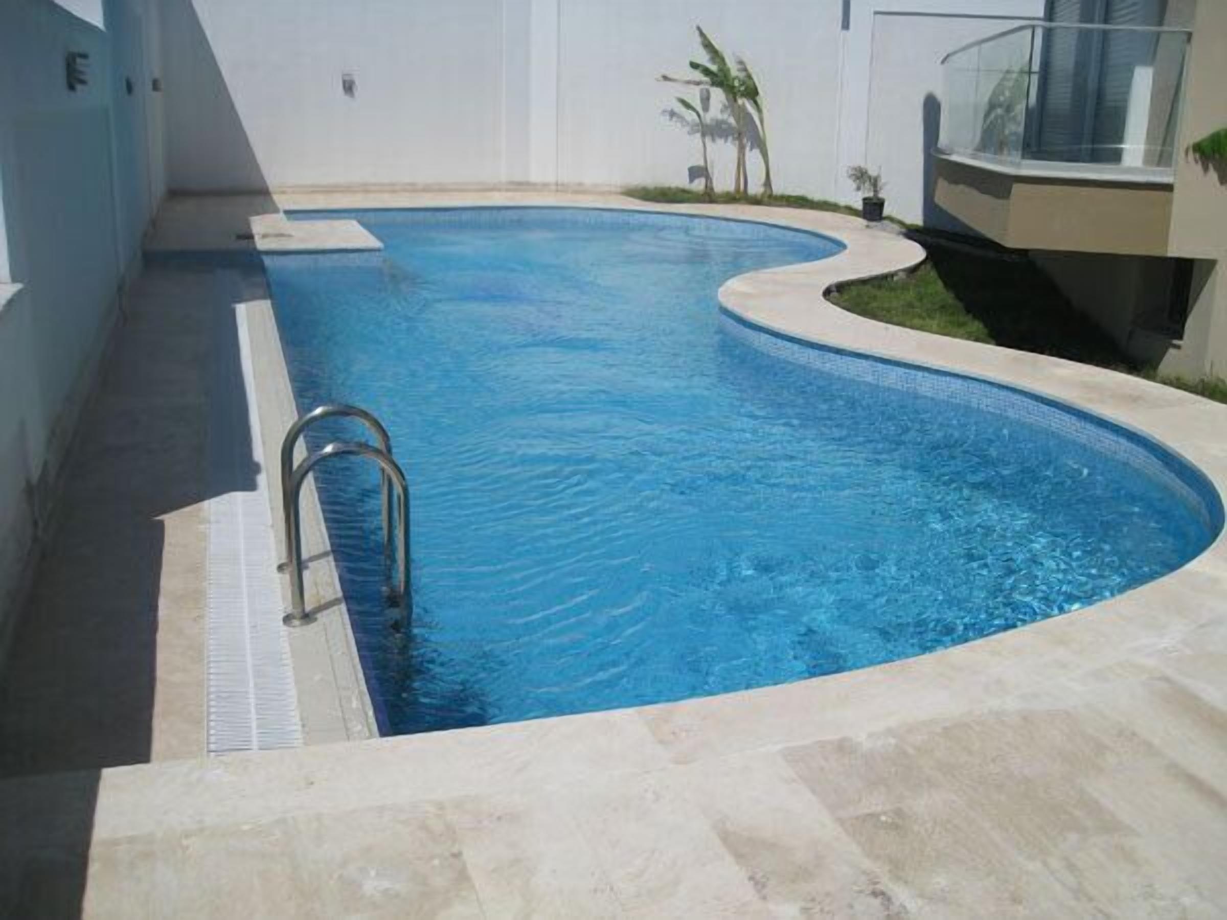 Alberca al aire libre, sombrillas en la alberca y camastros 