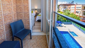 Un balcon avec une piscine, un coin salon et une vue sur la ville.