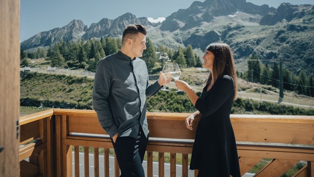A couple on a balcony overlooking a mountainous landscape. - Hotel Bezzi (Ponte di Legno)