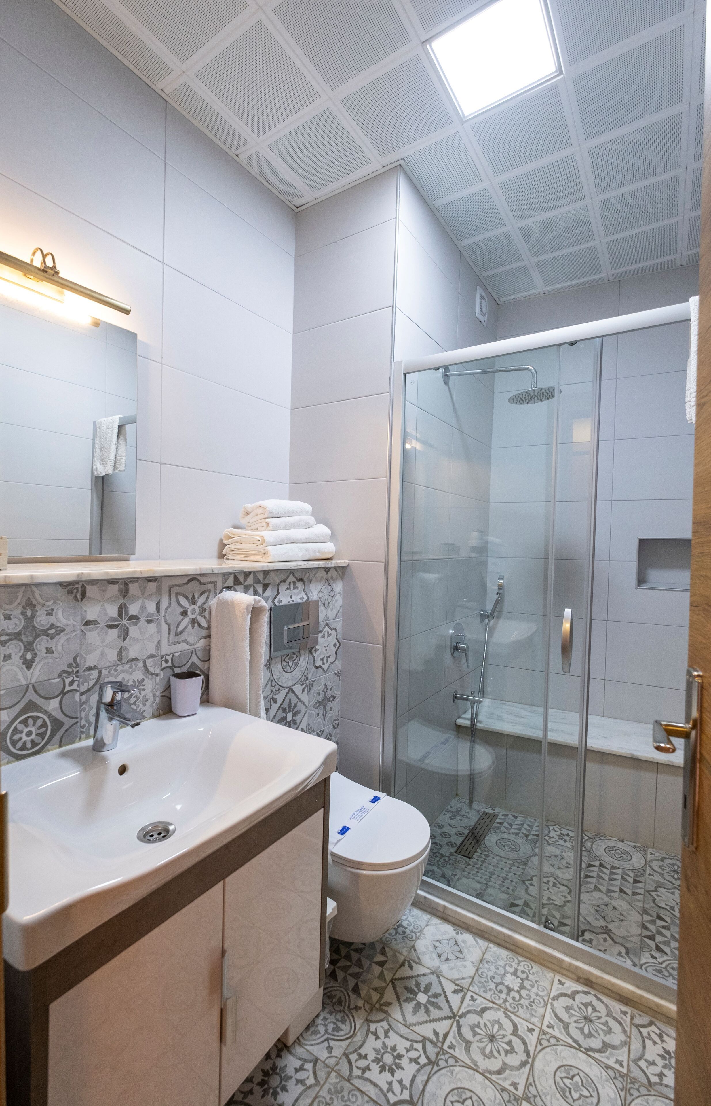 A bathroom with a sink, toilet, and glass-enclosed shower.
