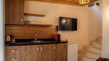 A kitchen with wooden cabinets, a black countertop, a built-in stove, and a small refrigerator.