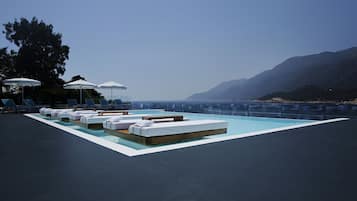 Una piscina al aire libre de temporada, sombrillas