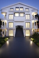 Una casa moderna de varios pisos con una escalera central, balcones y ventanas amplias.