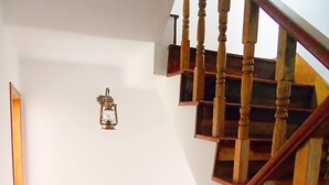 Eine Holztreppe mit Handlauf und Wandleuchte.