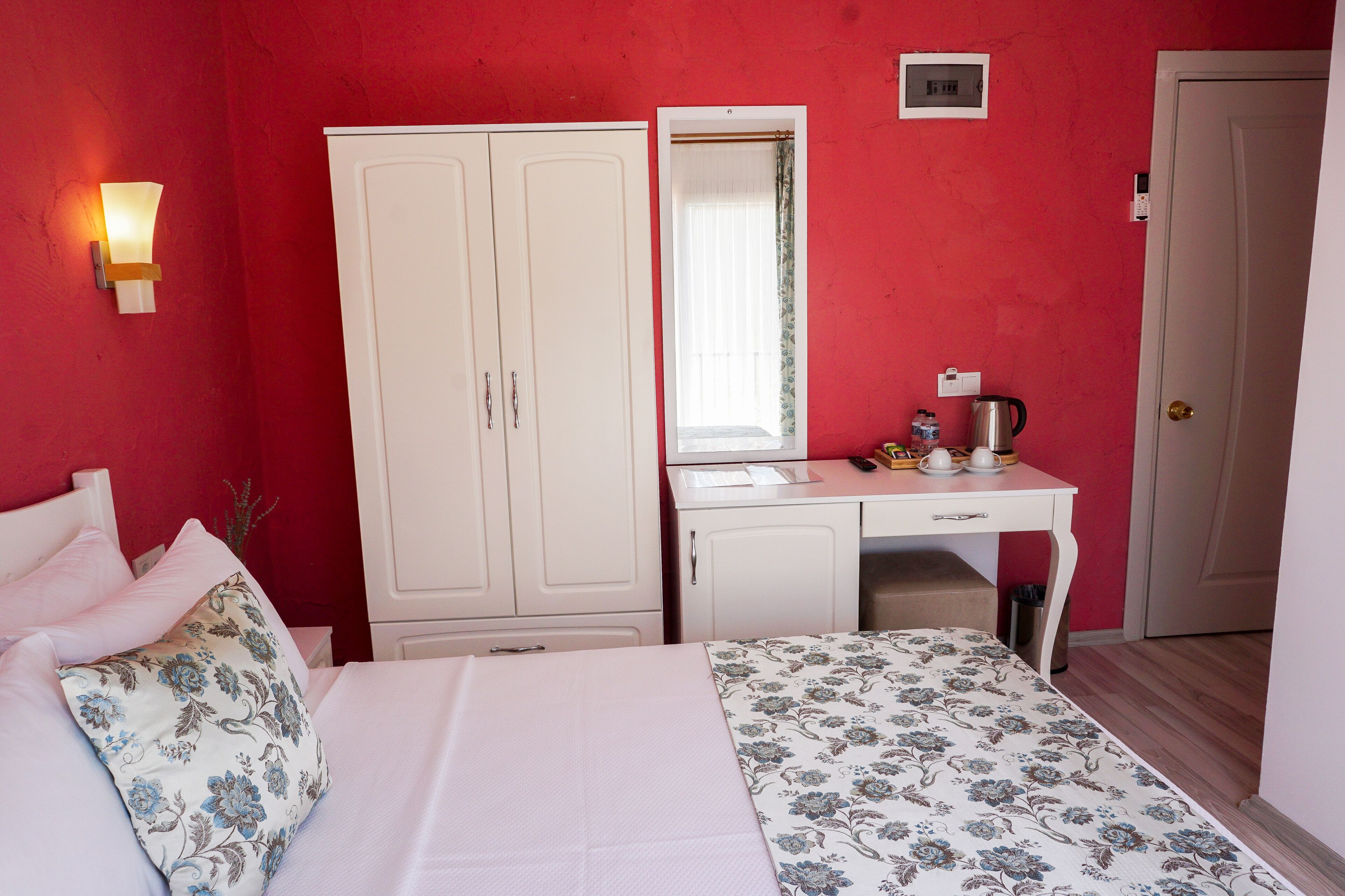 Een slaapkamer met een bed, een kledingkast, een bureau en een spiegel.