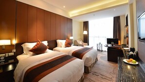 A hotel room with two beds, a desk with a TV, and a view of the city. - Excemon Yuyao Hemudu Hotel (Ningbo)