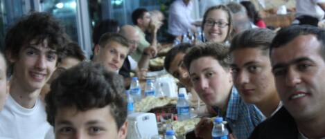 Un grupo de personas sentadas en una mesa en un restaurante, con botellas de agua y un menú.