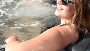 Une personne se détend dans un bain à remous en plein air.
