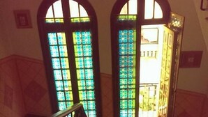 A staircase with ornate metal railings and stained glass windows. - Hotel Al Sogno (Alassio)