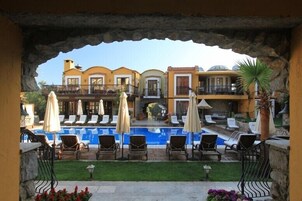 Una piscina al aire libre, sombrillas, sillones reclinables de piscina