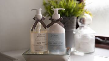 Twee flessen handzeep en bodylotion op een glazen dienblad.
