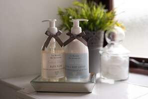 Two bottles of hand wash and body lotion on a glass tray. - Blessingbourne Country Estate (Fivemiletown)