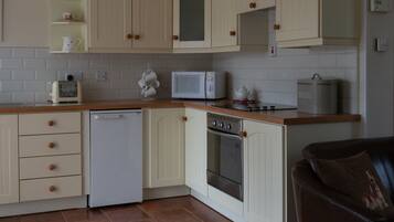 A kitchen with white cabinets, a microwave, a dishwasher, and a stove.