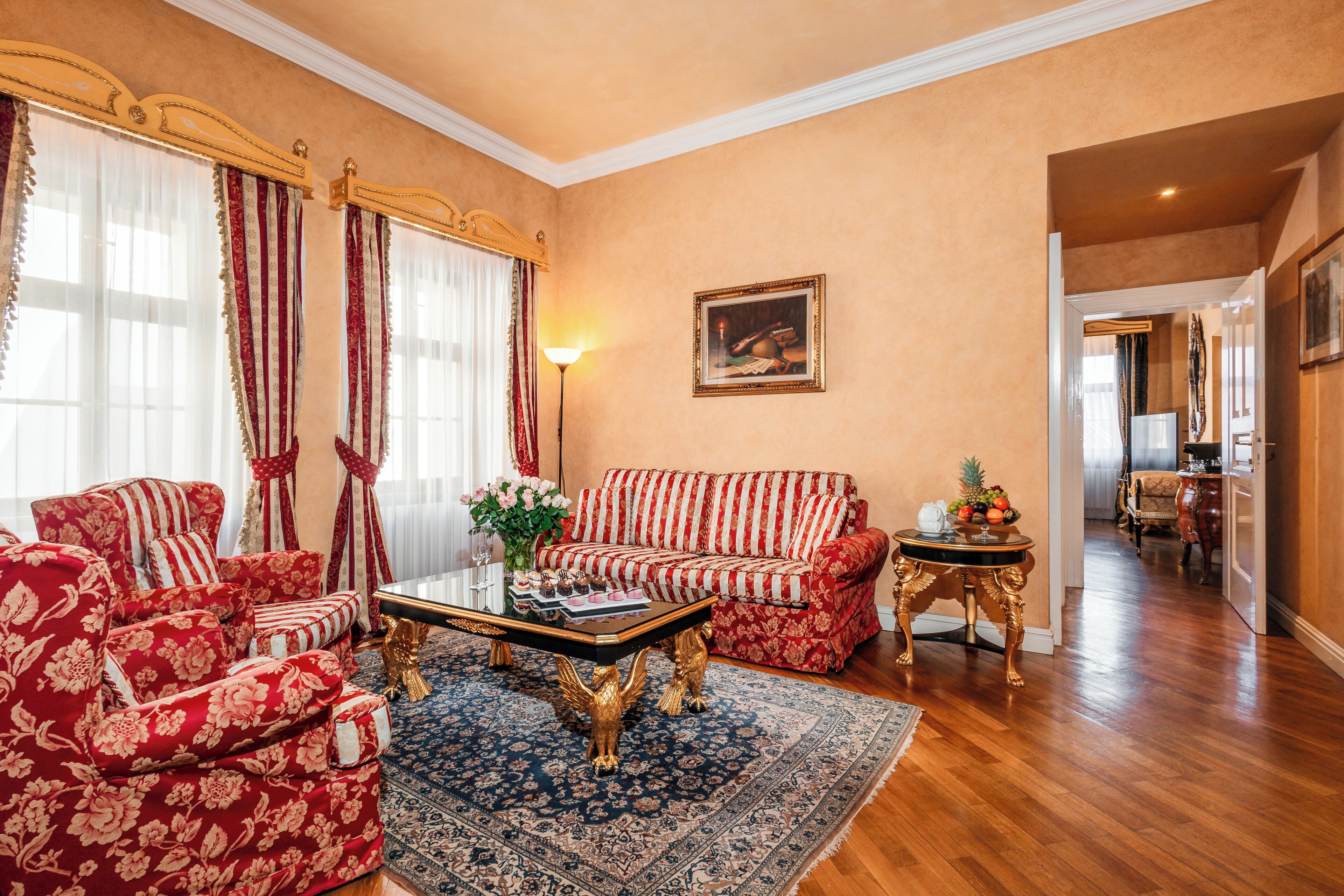 Een woonkamer met een bank, fauteuils, een salontafel en een vloerkleed.