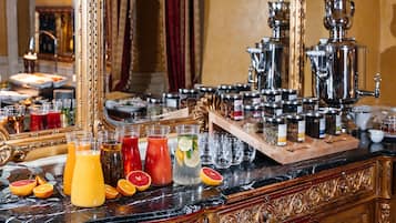 Zona de bar con diversas bebidas, entre ellas jugos y cócteles, además de copas y frascos con condimentos.