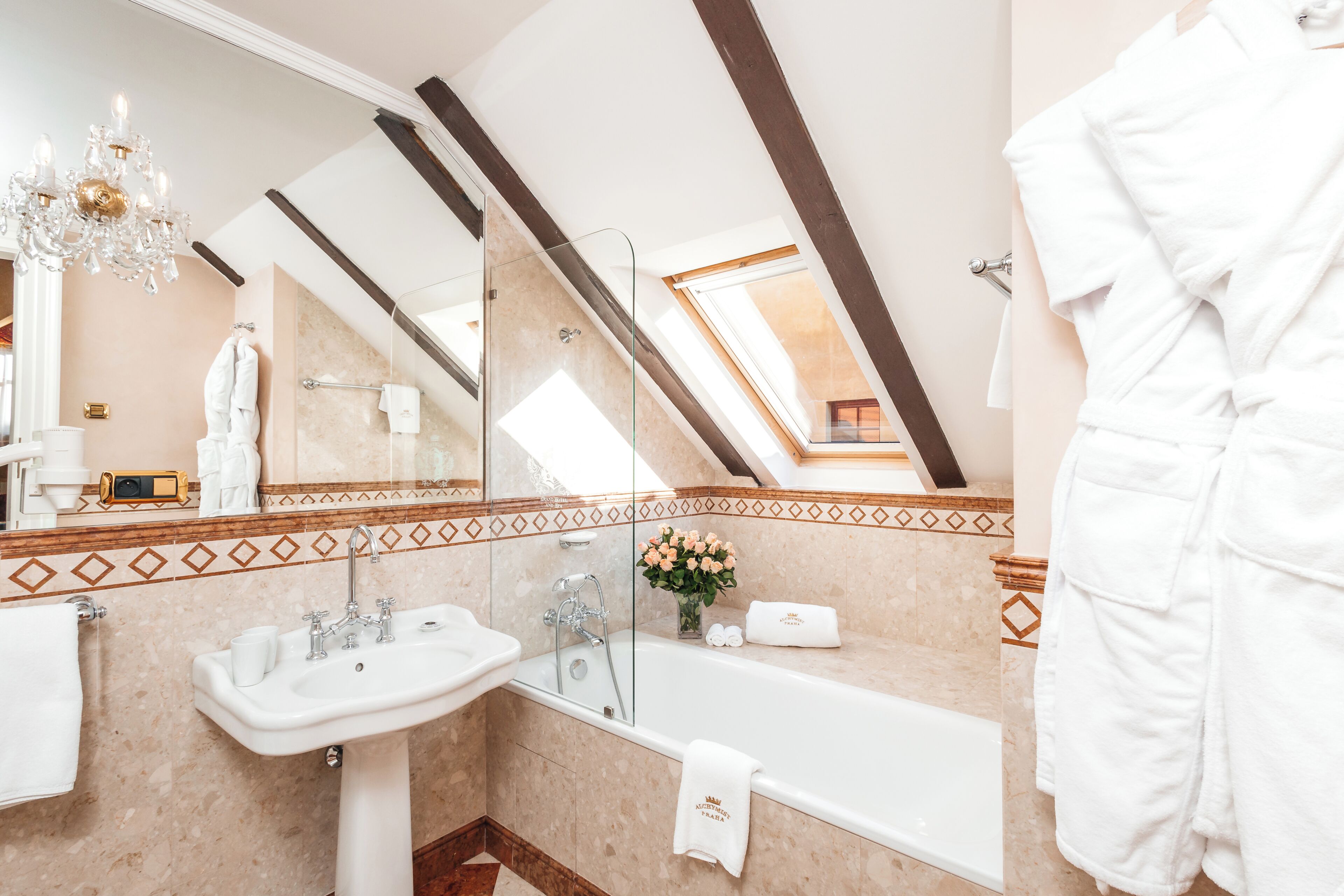 Une salle de bain moderne avec un puits de lumière, une baignoire, un lavabo et un miroir.